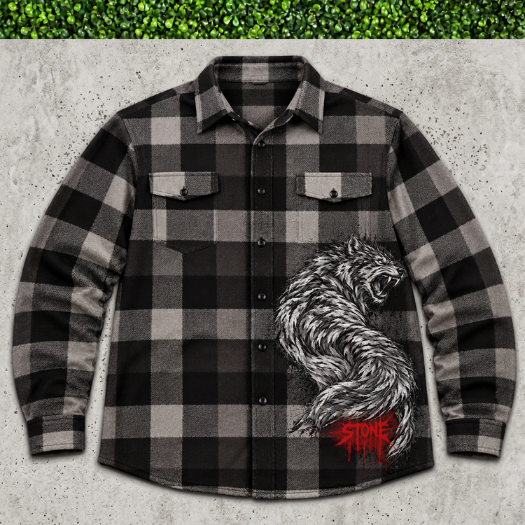 Black-and-gray STONE wolf plaid flannel flat lay on concrete with green grass above