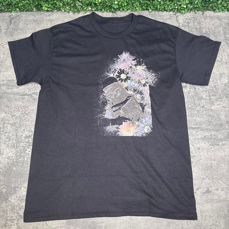 Black tee with an off-center pale gray collage and pastel flowers