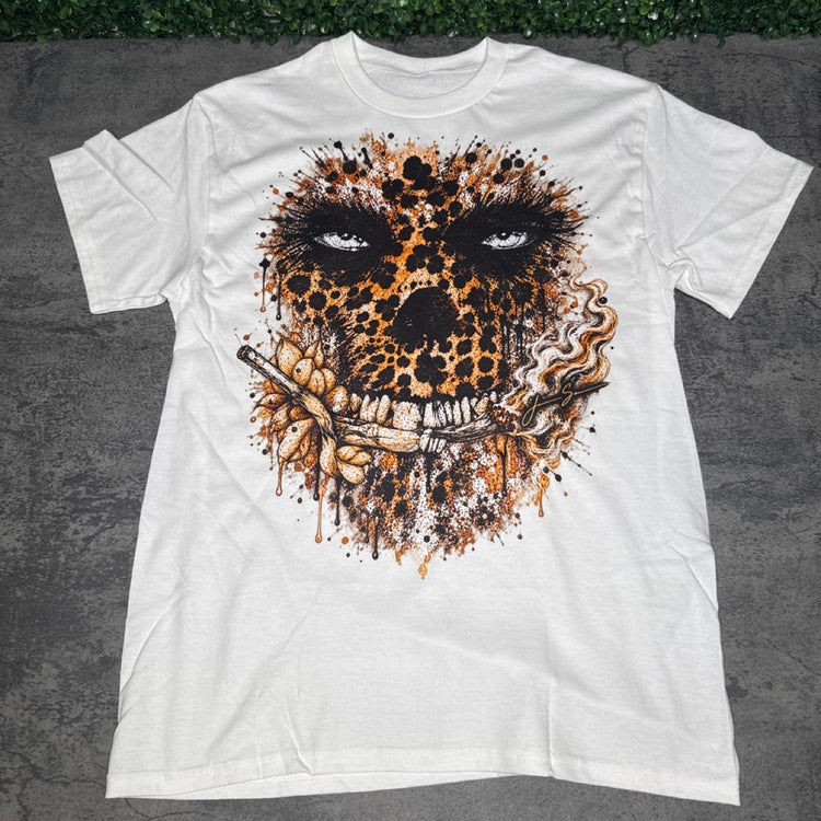 White tee with a gold-and-black leopard-pattern skull, floral accents and smoke details