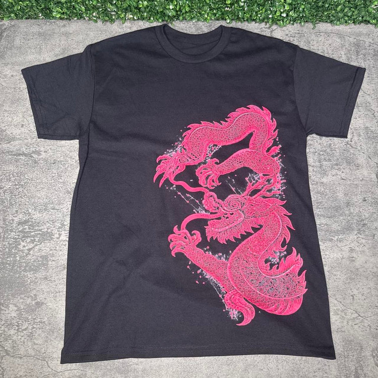 Black tee with an intricate pink dragon graphic sweeping down the front