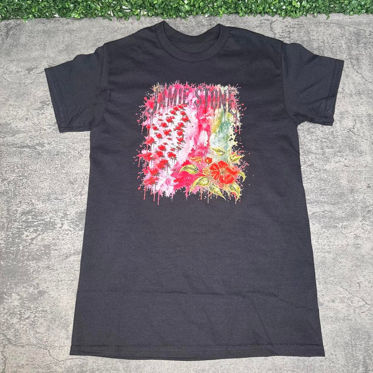 Black distressed cross graphic tee on gray concrete with green grass at the top