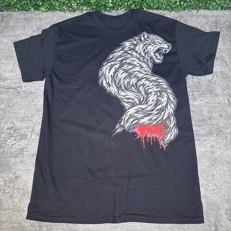 Black STONE Desert Decides tee flat lay on concrete with grass above