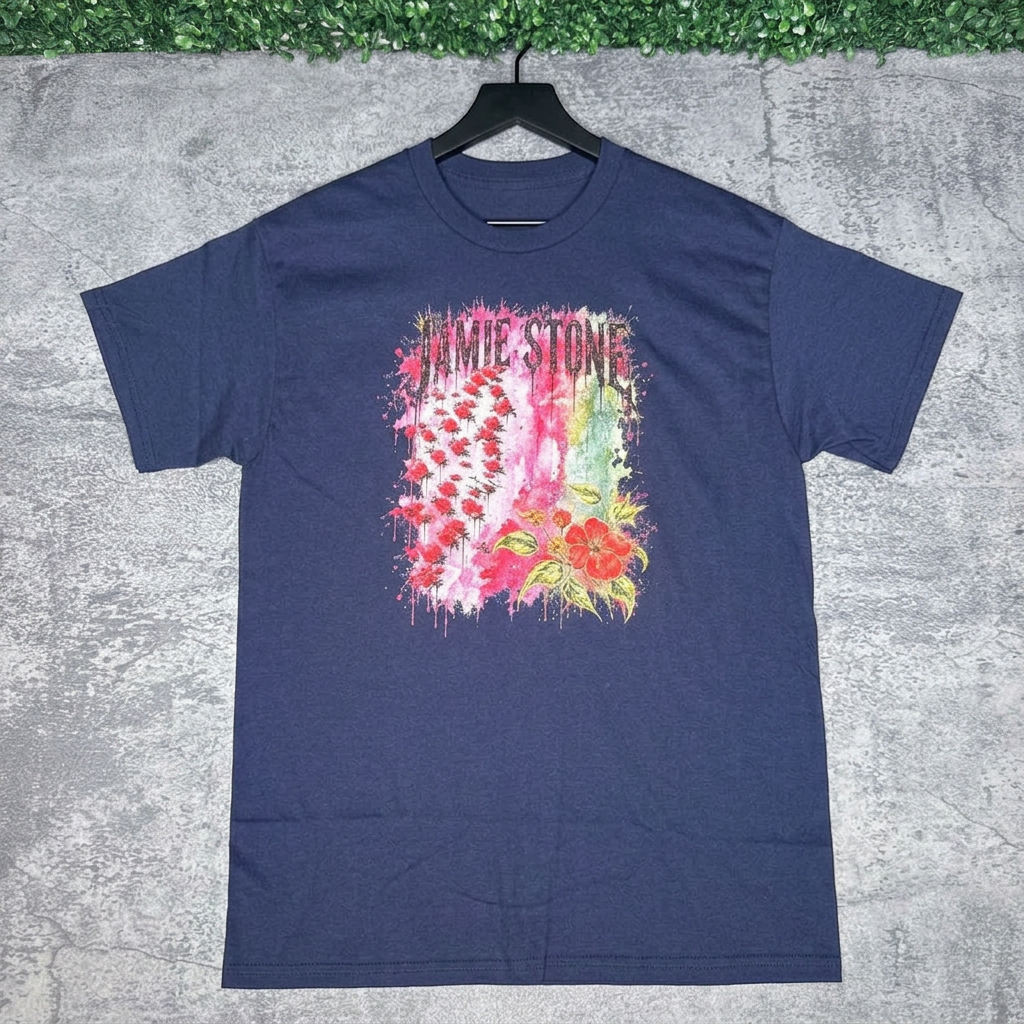 Navy blue Jamie Stone floral tee on a black hanger against gray concrete with green grass above