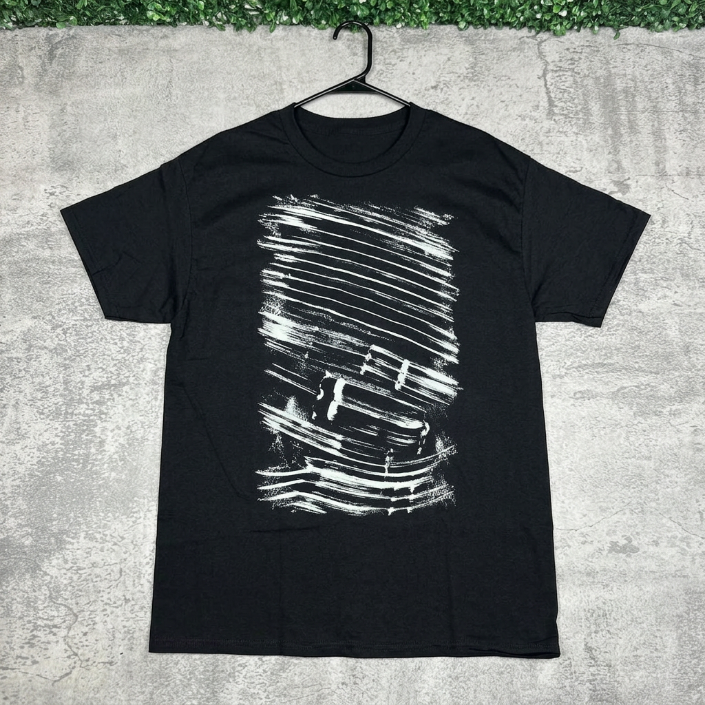 Black distressed brushstroke tee on a hanger against concrete with green grass above