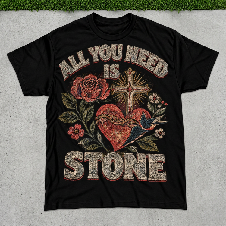 All You Need Is STONE black tattoo tee flat lay on concrete with grass above