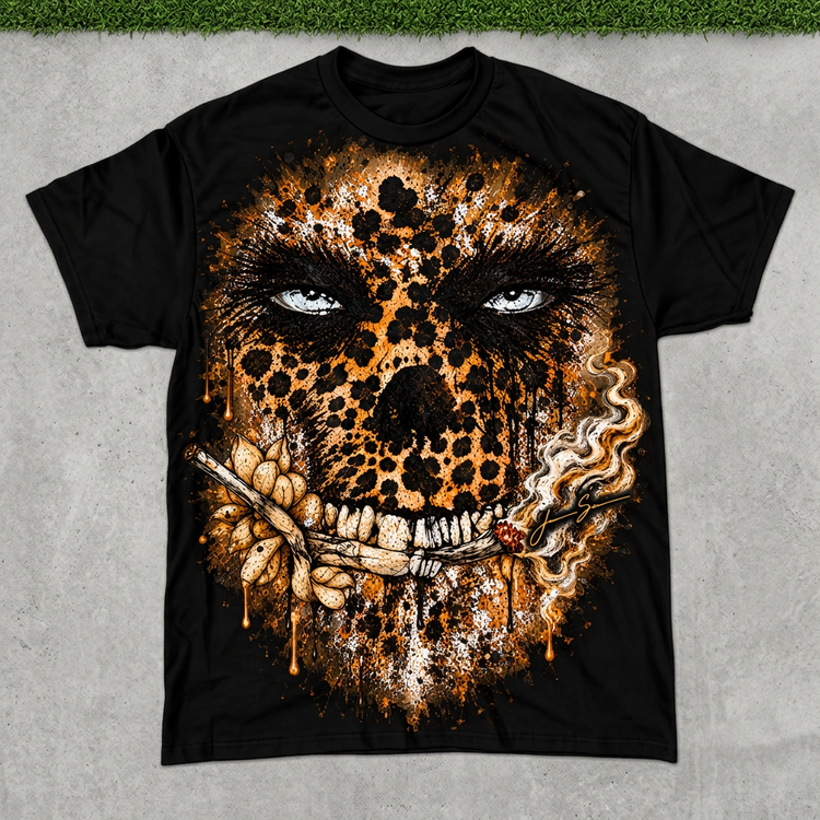 Black leopard skull tee flat lay on concrete with green grass above