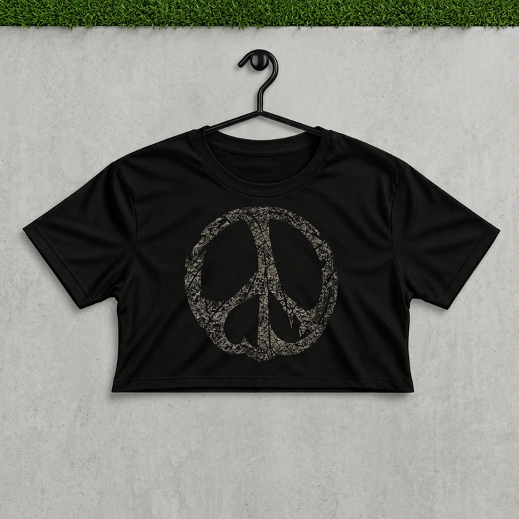 Distressed peace crop on a black hanger against concrete with grass above